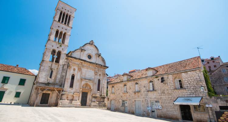 Église historique sur une place par une journée ensoleillée.