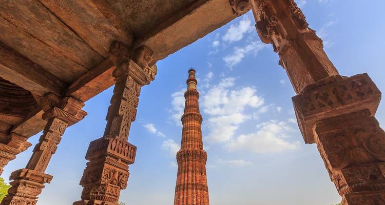 Tour Qutub Minar avec sculptures détaillées et ciel bleu.