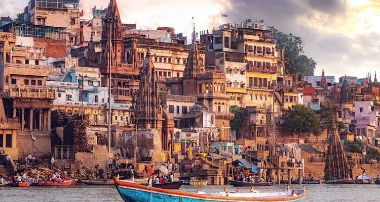 Drukke rivieroever met boten en historische gebouwen bij zonsondergang