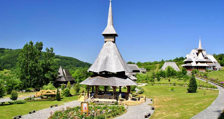 Wooden church pavilion surrounded by lush green gardens on a bright summer day