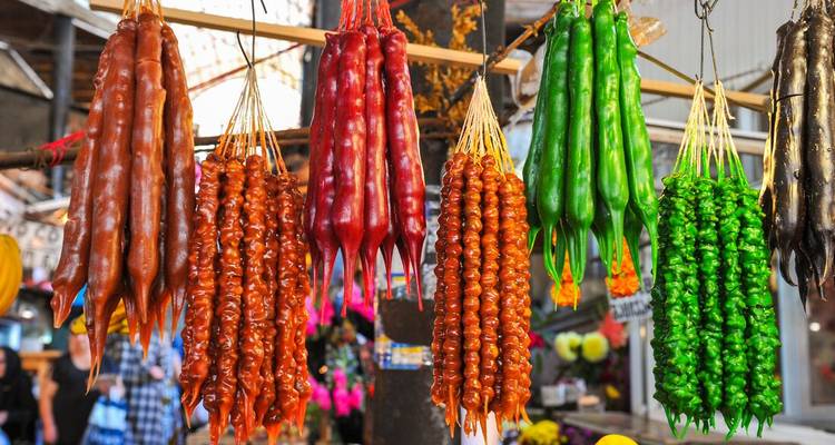 Filas de dulces georgianos churchkhela de colores colgando en un puesto de mercado al aire libre