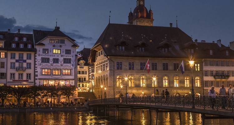 Historische Europese gebouwen aan een rivier bij schemering.