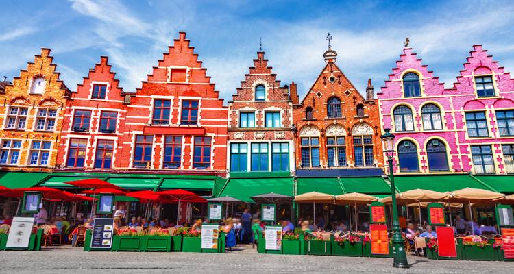Colorful gabled houses in a city square with outdoor dining.