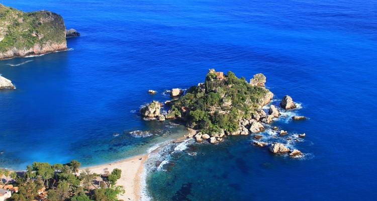 Vue aérienne des criques turquoise et de la minuscule Isola Bella verdoyante au large de la côte sicilienne.