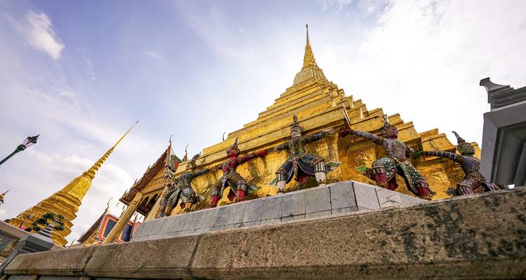 Pagode dorée avec des figures mythiques qui montent la garde.