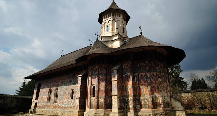 Église avec fresques traditionnelles et toit voûté.