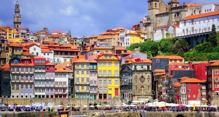 Bunte Gebäude in Porto entlang einer Flusspromenade.