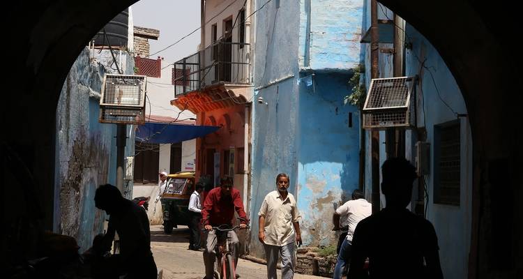 Escena callejera con personas caminando bajo un arco.