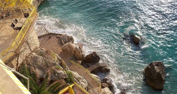 Seascape with rocky shore and turquoise waters.