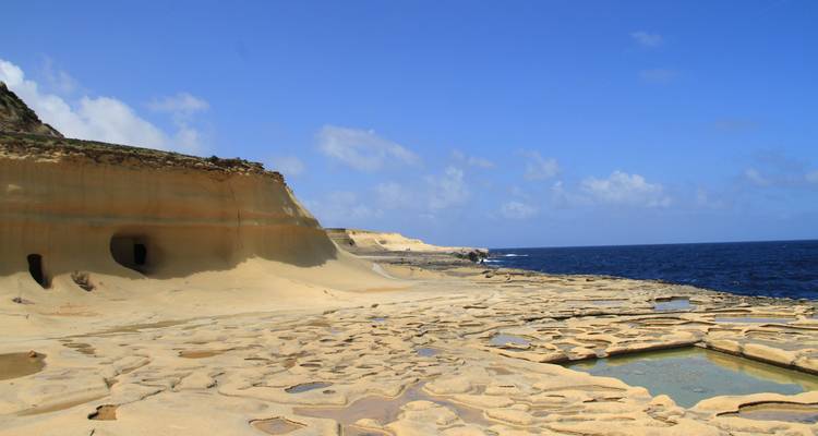 Un littoral accidenté avec des formations de grès érodées en bord de mer.