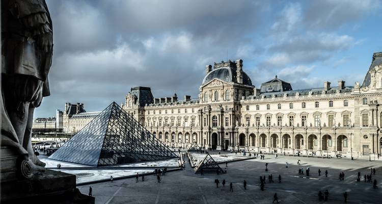 Louvre Museum with glass pyramid in the courtyard.