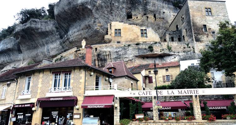 Un café construit à flanc de falaise avec une architecture traditionnelle.