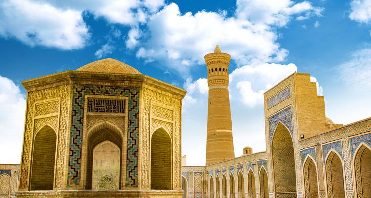 Un complejo histórico de mezquitas con una torre en pie y edificios ornamentados con azulejos.