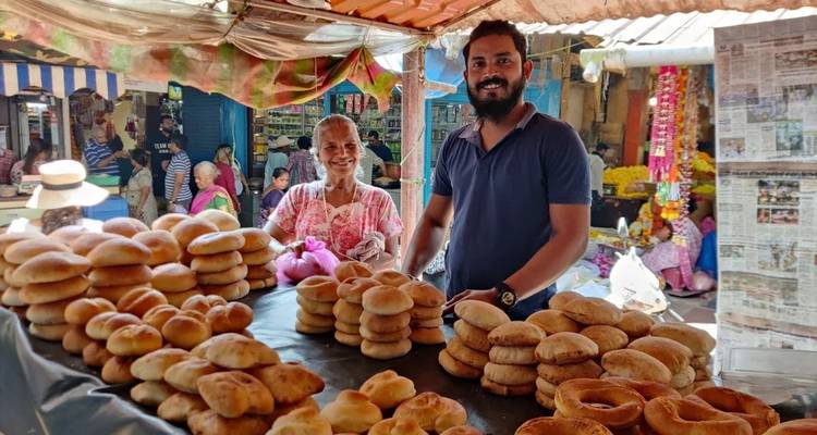 People at a market stall selling traditional food items.