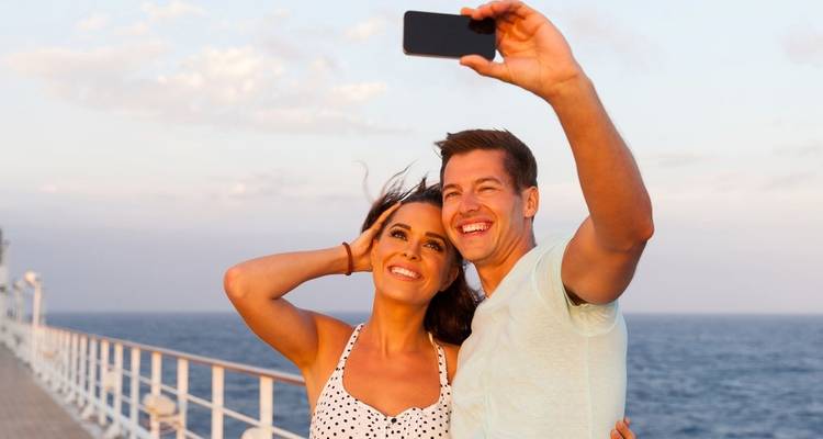 Couple taking a selfie on a ship deck.