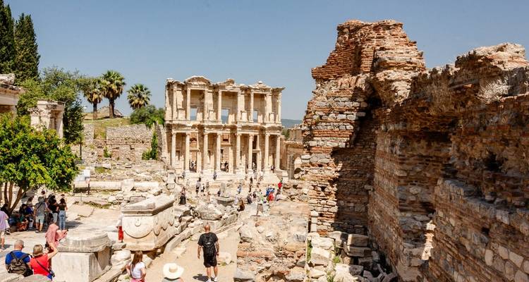 Ruines d'une ancienne bibliothèque avec des touristes autour.
