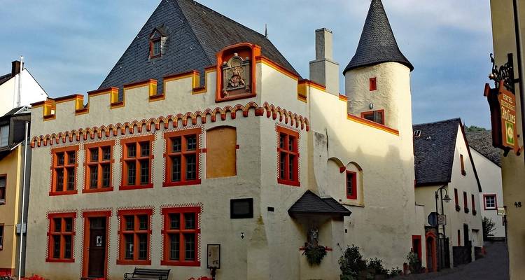 Una pintoresca casa medieval con detalles rojos y torretas.