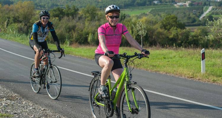 Two cyclists riding on a road.