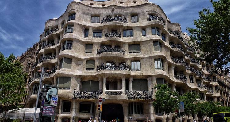 Façade ondulée en pierre de la Casa Milà (La Pedrera) de Gaudí contre un ciel ensoleillé à Barcelone.