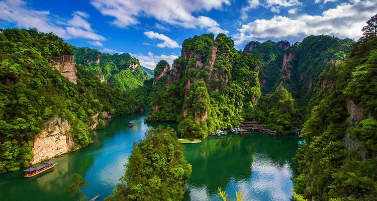 Río esmeralda espectacular serpenteando entre imponentes pilares de arenisca y selva exuberante en el Parque Nacional de Zhangjiajie.