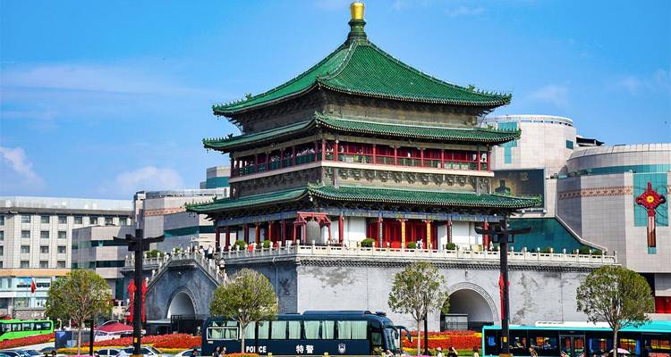 La histórica Torre de la Campana de Xi'an destacándose entre edificios modernos en un día soleado.