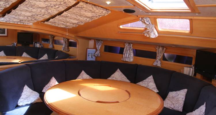 Dining and loung area on a yacht with lots of pillows.