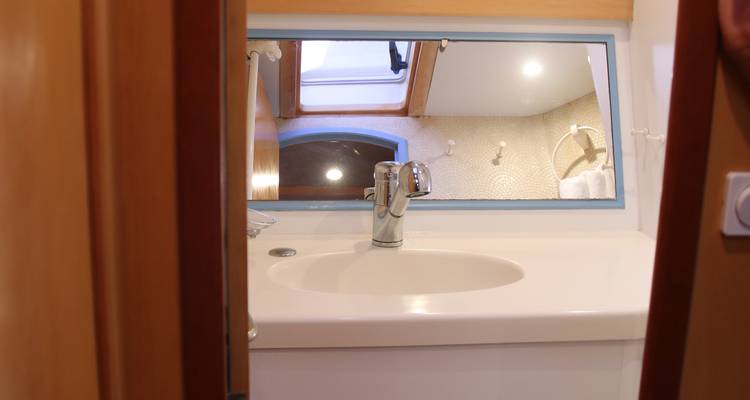 Sink and mirror in a yacht bathroom with soft lighting.