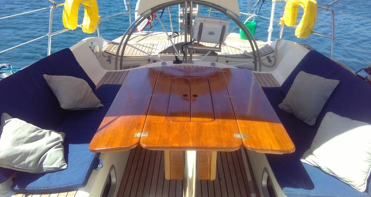 Dining area on a yacht with wooden table and cushioned seating.