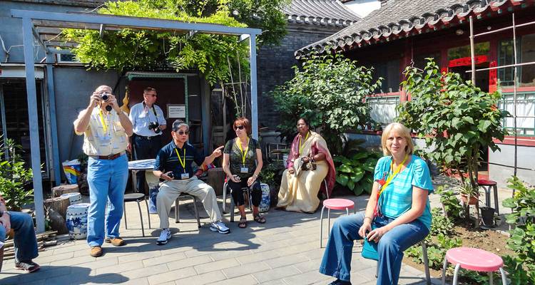 Des personnes assises dans une cour avec une décoration chinoise traditionnelle.