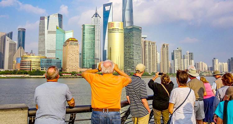 Des touristes admirant l'horizon moderne de Shanghai depuis le Bund.