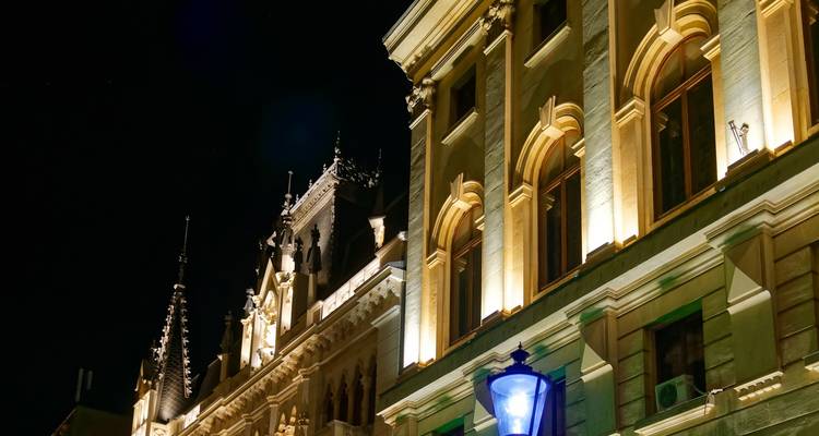 Edificios iluminados por la noche con detalles arquitectónicos.