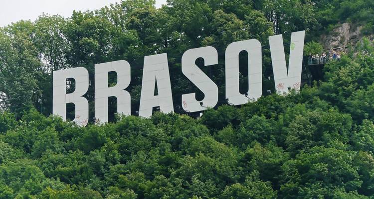 Grandes letras blancas que deletrean 'BRASOV' en una ladera.