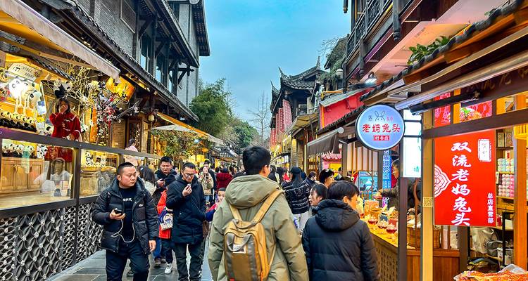 Geschäftiger Straßenmarkt mit Menschen beim Einkaufen und traditionellen Geschäften.