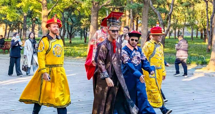 Les visiteurs internationaux se promènent dans des costumes impériaux aux couleurs vives à travers un parc urbain.