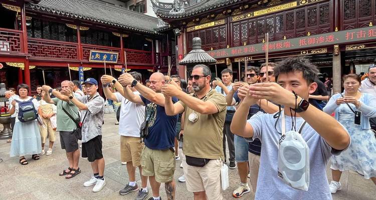 Touristen, die während einer rituellen Vorführung Räucherstäbchen in einem traditionellen chinesischen Innenhof-Tempel halten.