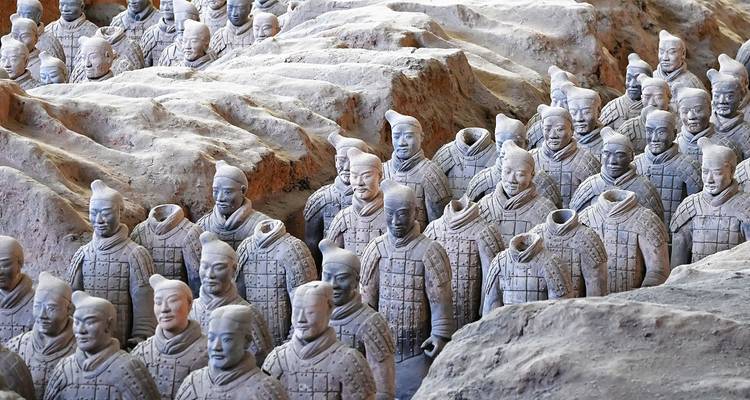 Reihen berühmter Terrakotta-Krieger stehen in Ausgrabungsgruben in Xi'an, wobei einigen Statuen die Köpfe fehlen.