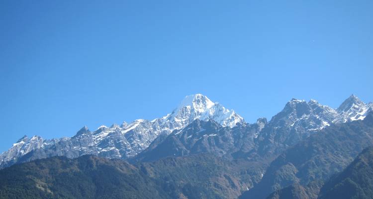 Klare Sicht auf schroffe Berge unter sonnigem Himmel.