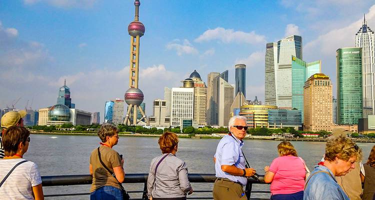 Des touristes admirant l'horizon de la ville moderne depuis le front de mer.