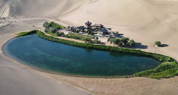 Luftaufnahme der Crescent Lake-Oase und des antiken Pavillonkomplexes, umgeben von ausgedehnten Sanddünen