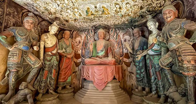 Aufwendige buddhistische Skulpturen und Wandmalereien in einer reich verzierten Mogao-Höhlenkammer