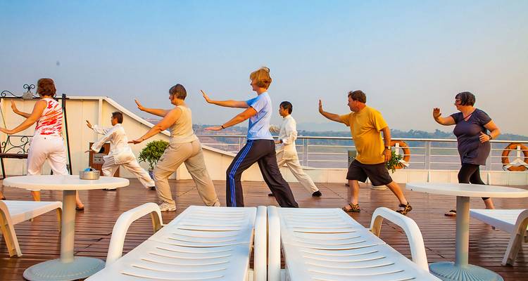 Mensen die Tai Chi beoefenen op het dek van een schip.