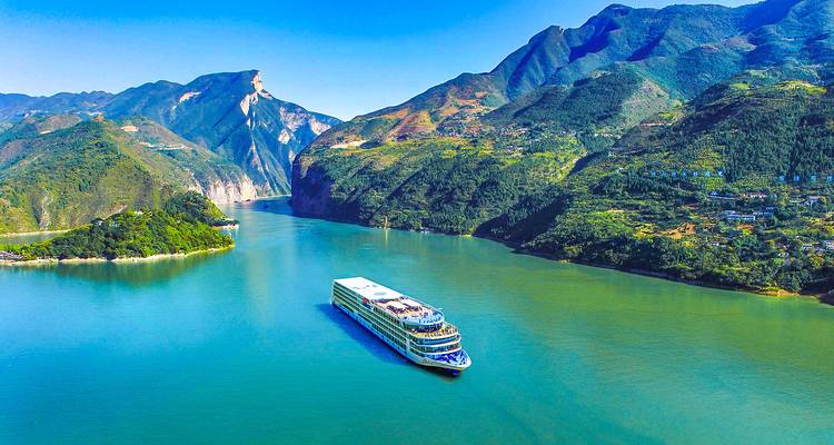 Cruiseschip dat door schilderachtige bergen en rivier vaart.