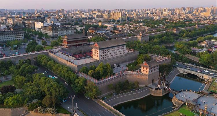 Vista aérea del complejo masivo de la muralla de Xi'an rodeado del horizonte urbano moderno y el foso del río.