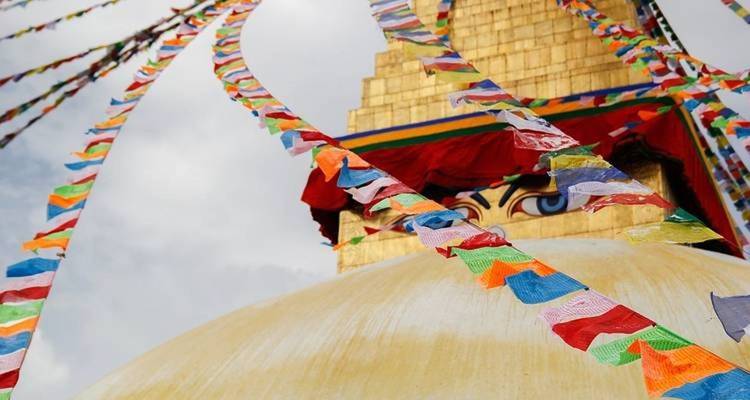 Una estupa con banderas de oración coloridas bajo un cielo despejado.