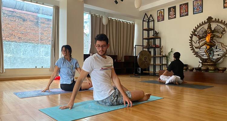 Participants dans un cours de yoga dans un studio décoré.