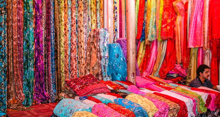 Exhibición vibrante de telas coloridas en un ambiente de mercado.
