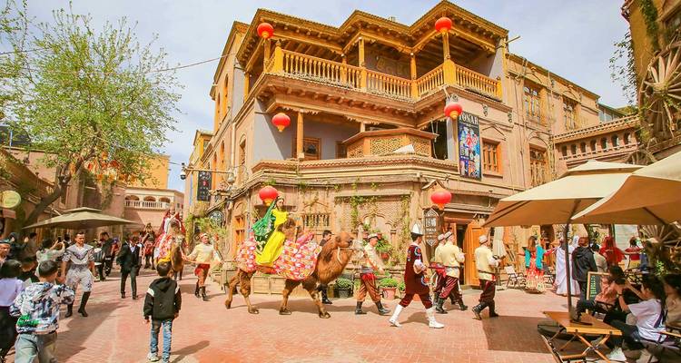 Kleurrijke straatprocessie met kamelen en performers in de historische oude stad van Kashgar.