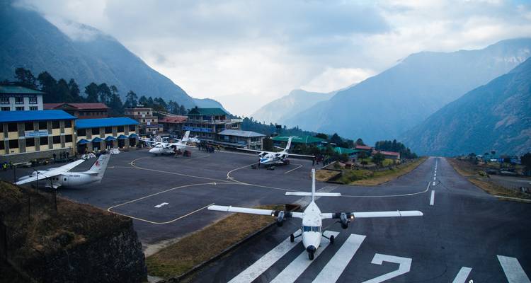 Petit aéroport entouré de montagnes dans une région vallonnée.