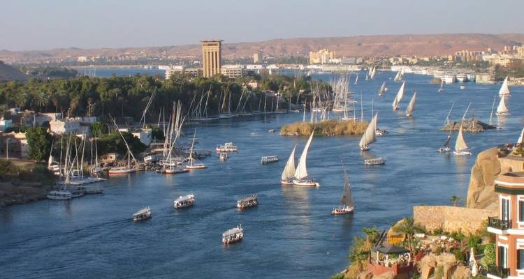 Scenic view of the Nile River with boats and a city skyline.
