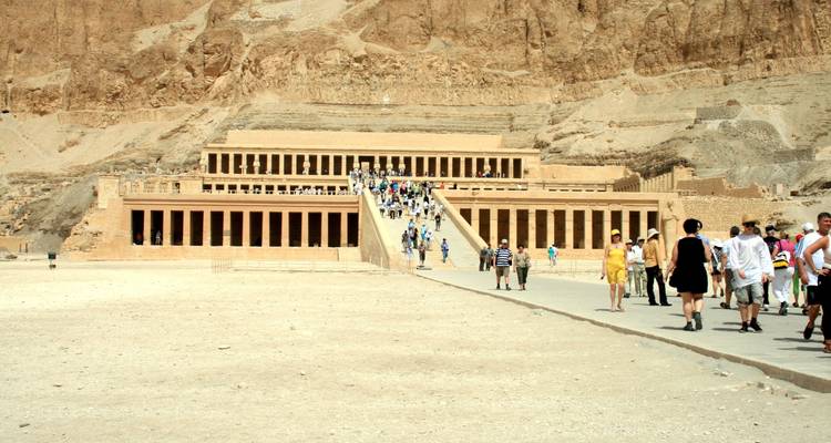 Toeristen die een grote oude structuur verkennen.